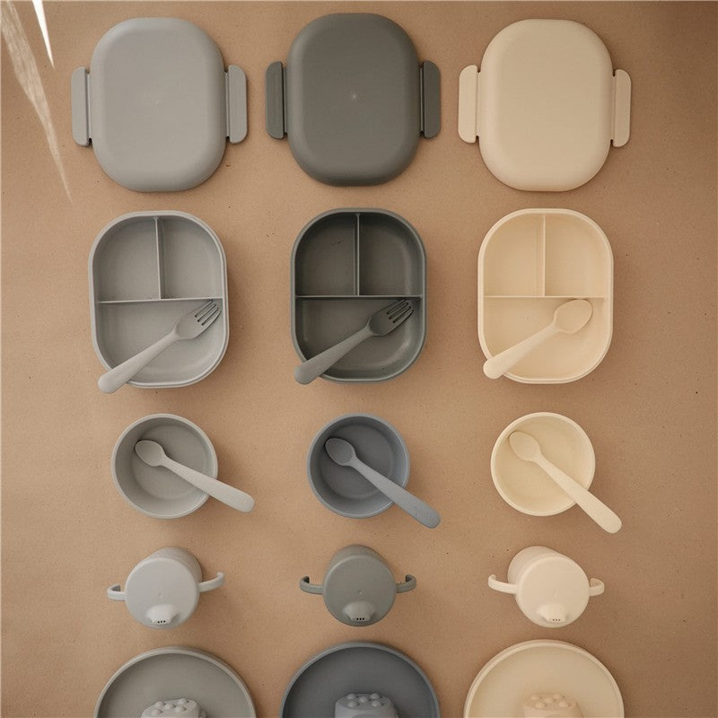 Mushie Bento Lunch Box in cloud color, featuring various sizes and compartments, made from soft silicone with utensils.