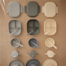 Mushie Bento Lunch Box in cloud color, featuring various sizes and compartments, made from soft silicone with utensils.