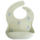 Mushie Silicone Baby Bib in Bluey Sage with blue character illustrations and a pocket for catching food.