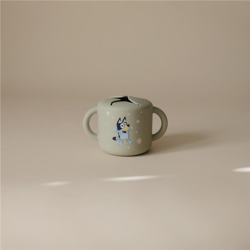 Bluey X Mushie snack cup in sage green featuring a playful Bluey design and two easy-to-grip handles.