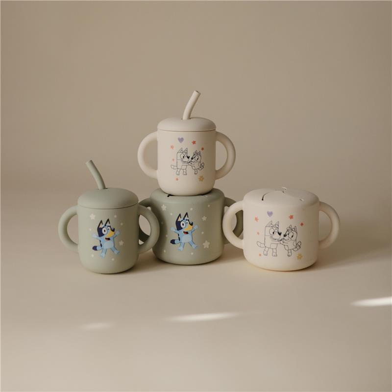 Bluey X Mushie snack cups in sage and neutral colors, featuring fun cartoon designs of Bluey and friends, stacked together.