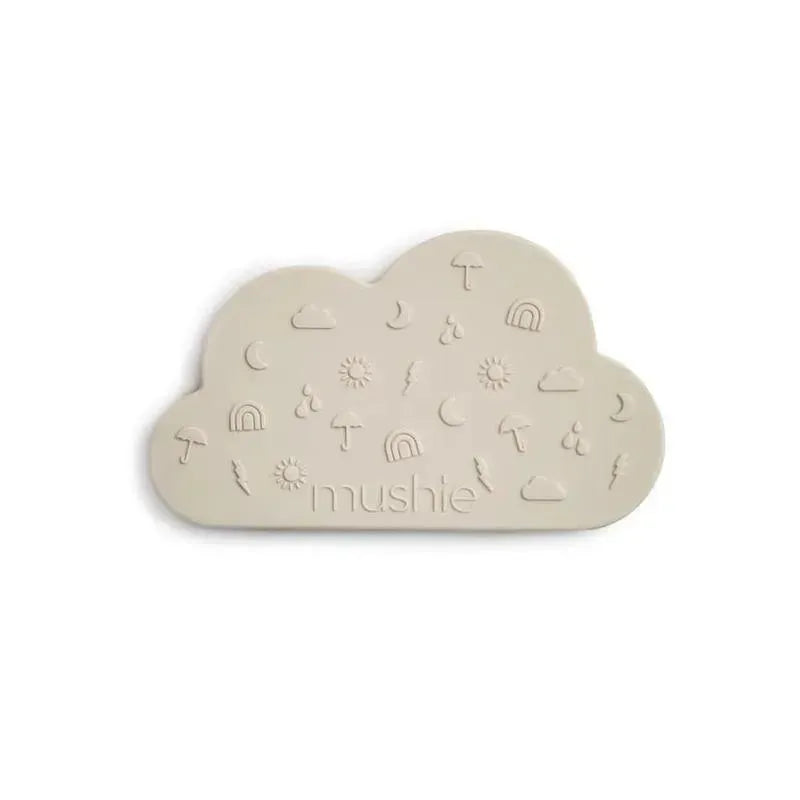 Mushie Cloud Teether in Shifting Sand color, shaped like a cloud with embossed sun, rainbow, and raindrop designs.