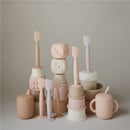 Silicone diaper cream applicators and containers in various soft colors, showcasing their playful and functional design.