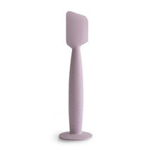Soft lilac Mushie diaper cream applicator made of silicone, featuring a suction base for easy use.