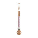 Mushie Eva pacifier clip in mauve featuring wooden beads and a metal clip for securing pacifiers.