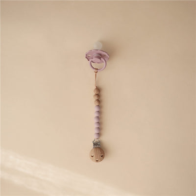 Mushie Eva pacifier clip in mauve with wood and silicone beads, designed to secure pacifiers and prevent loss.