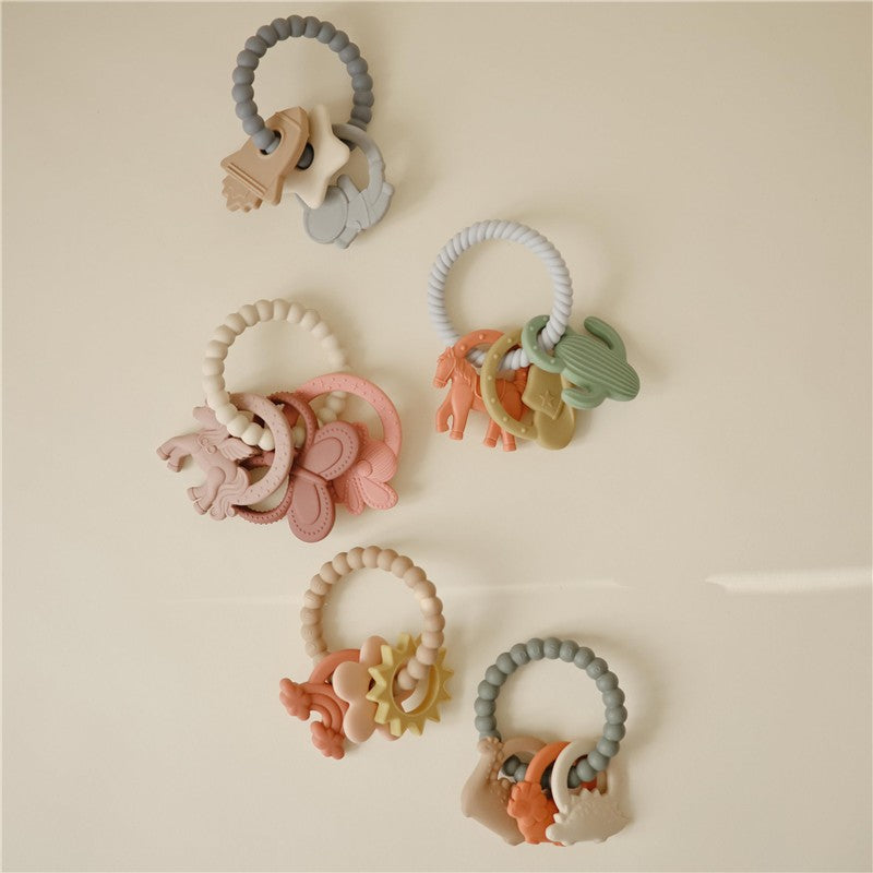 Mushie Fairy Teething Ring set featuring colorful silicone rings with animal shapes, designed for soothing teething babies.