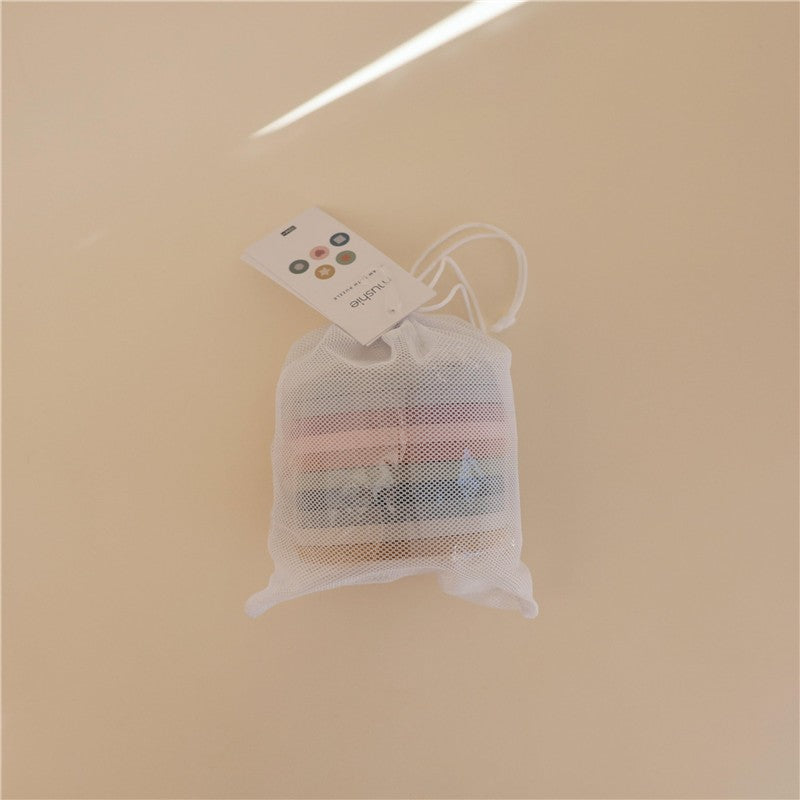 Mushie Foam Bath Puzzle in a mesh bag, featuring colorful foam pieces for bath time play.