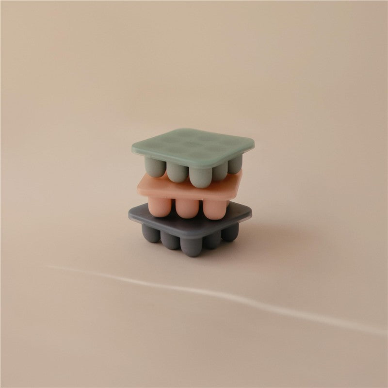 Mushie Fresh Food Feeder Freezer Tray set in Cambridge Blue, featuring stacked silicone trays in green, peach, and grey.