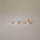 Four cream-colored pacifiers designed for babies 0-6 months, featuring various shapes and a calming aesthetic.