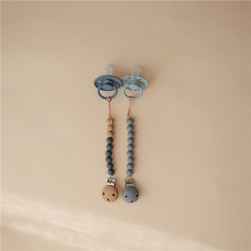 Silicone pacifier clips in blue tones, featuring beads and wooden accent, designed for securing pacifiers.
