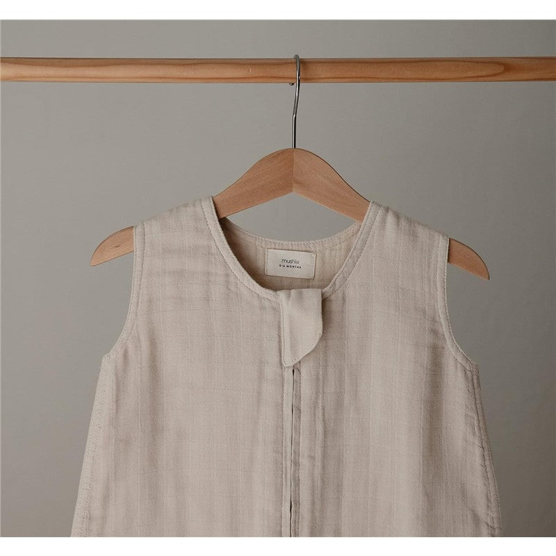 Mushie Muslin Sleep Bag in Fog, featuring soft, textured fabric, sleeveless design, and a front snap closure.