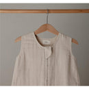 Mushie Muslin Sleep Bag in Fog, featuring soft, textured fabric, sleeveless design, and a front snap closure.