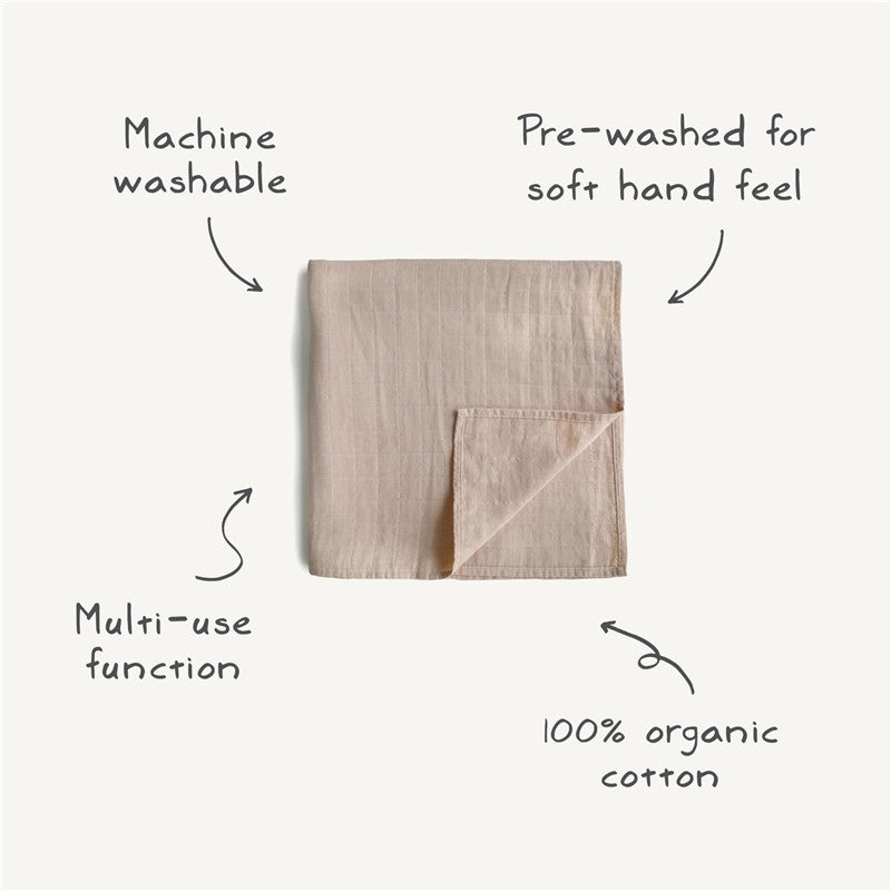 Mushie Organic Cotton Muslin Swaddle Blanket in Rose Vanilla, highlighting its machine washable, pre-washed soft feel, and multi-use function.