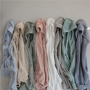 Soft, hooded towels in various colors including baby blue, stacked neatly, showcasing texture and design for baby bathing.