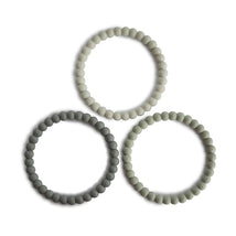 Mushie Pearl Teething Bracelet set in green tea, cool gray, and sea salt colors, designed for soothing teething infants.