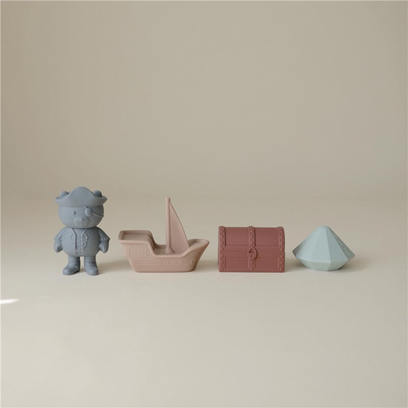 Mushie Pirate Mold Free Bath Play Set featuring a pirate figure, a sailboat, a treasure chest, and a geometric shape.