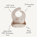 Silicone baby bib featuring a deep pocket and colorful dinosaur prints; made from 100% food-grade silicone, dishwasher safe, BPA-free.