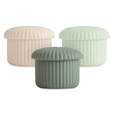 Silicone baby food containers in green, mint, and cream colors, featuring ribbed designs and matching lids.