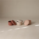 Mushie silicone baby food containers in pink shades, featuring textured lids and an open design for easy access.