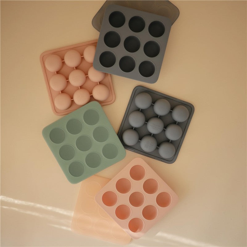 Mushie Baby Food Freezer Trays in Cambridge Blue and various colors, arranged with round compartments for freezing baby food.