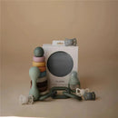 Silicone baby links teether toy by Mushie in various colors with packaging visible, showcasing its design and purpose.