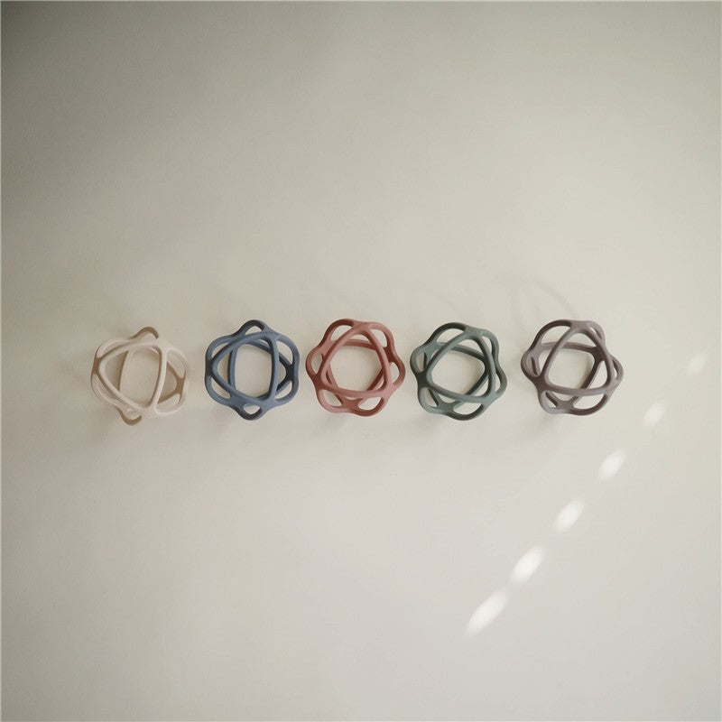 Mushie Silicone Ball Teether in various colors displayed on a neutral background, designed for teething relief.