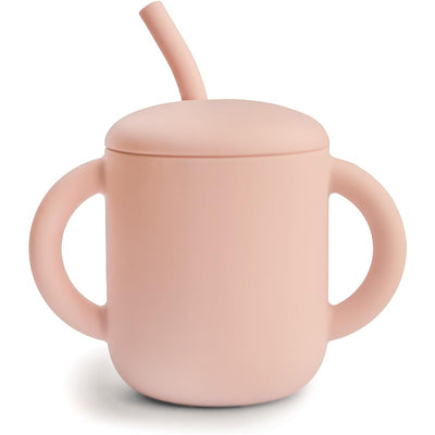 Mushie silicone training cup in blush color with a straw and two easy-grip handles.