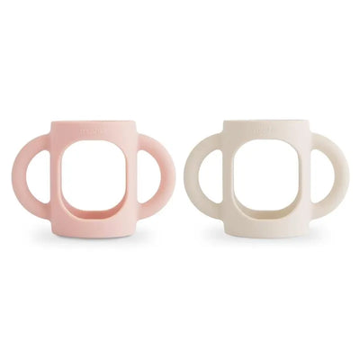 Silicone bottle handles in blush and shifting sand colors, designed for easy gripping by children.