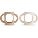 Silicone bottle handles in natural and shifting sand colors, designed for easy gripping by children.