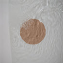 Mushie silicone drain stopper in blush color floats on water surface, designed to prevent drainage while enhancing decor.