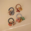 Silicone teething rings in various colors and shapes, including animals and rainbows, designed for infants.