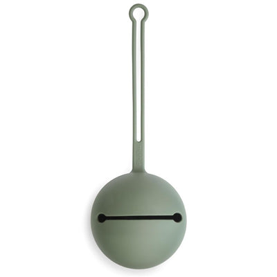 Mushie silicone pacifier holder case in dried thyme color, featuring a round design with a loop for attachment and slit for pacifier.