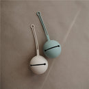 Silicone pacifier holder cases in dried thyme and neutral colors, designed for convenient storage.