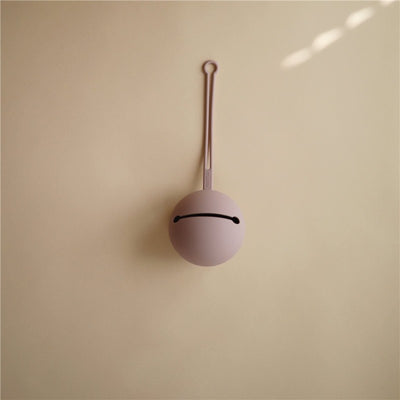 Soft lilac silicone pacifier holder case with a loop for attachment, featuring a subtle smile design.
