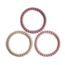 Mushie Pearl Teething Bracelets in linen, peony, and pale pink, designed for soothing infants during teething.