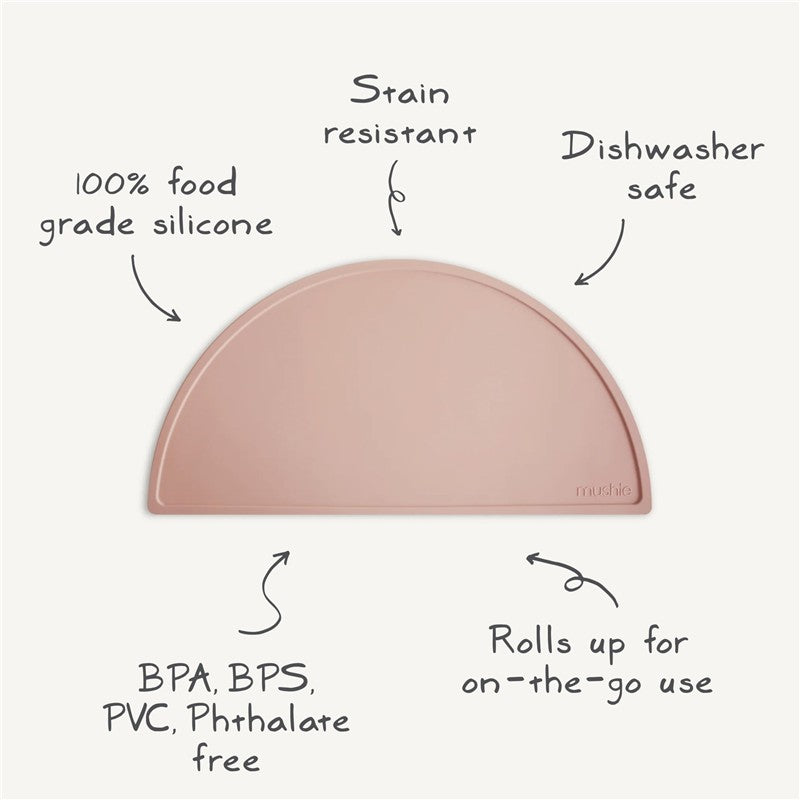 Silicone placemat in soft pink, made from food-grade silicone, stain resistant, dishwasher safe, rolls up for easy storage.