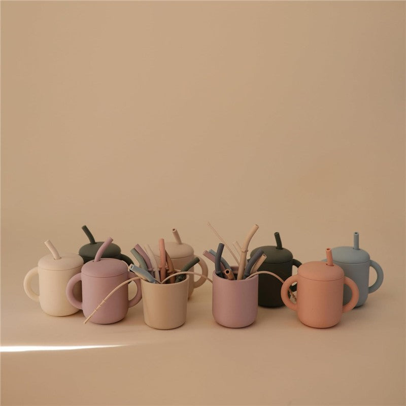 Silicone replacement straws in various colors grouped in playful cups against a neutral background.