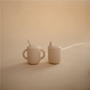Silicone sippy cup set in shifting sand color, featuring a cup with a straw and a small lid.
