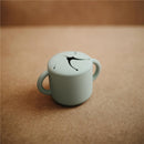 Mushie Silicone Snack Cup in Cambridge Blue, featuring a smooth finish and two handles, ideal for toddlers.