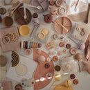 Mushie Silicone Suction Plate in Cloudy Mauve, surrounded by various playful feeding and learning accessories.