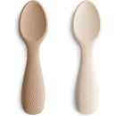 Silicone toddler starter spoons in natural and shifting sand colors, featuring rounded edges and ergonomic handles.