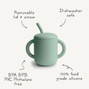 Powder blue silicone training cup with a removable lid and straw, marked dishwasher safe and made from 100% food grade silicone.