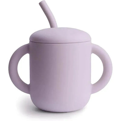 Silicone training cup in soft lilac with a removable lid and straw, featuring two handle grips for easy use.