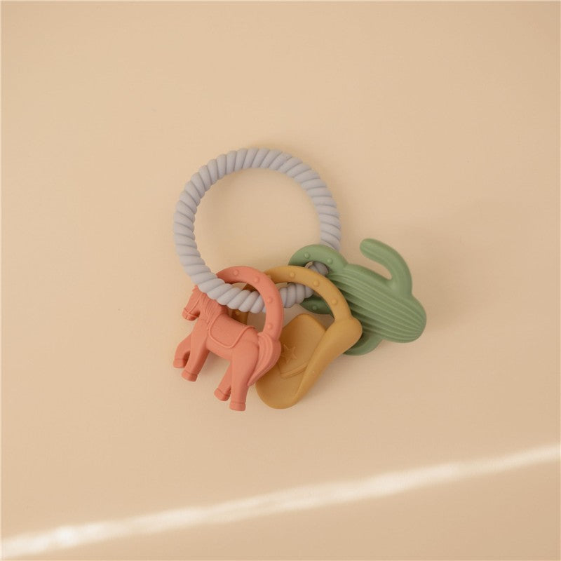 Silicone teething ring set featuring colorful animal shapes, including a horse and cactus, on a soft, neutral background.