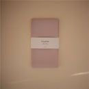 Mushie Splat Mat in blush color, featuring a white band with brand name and product details, laid flat on a neutral background.