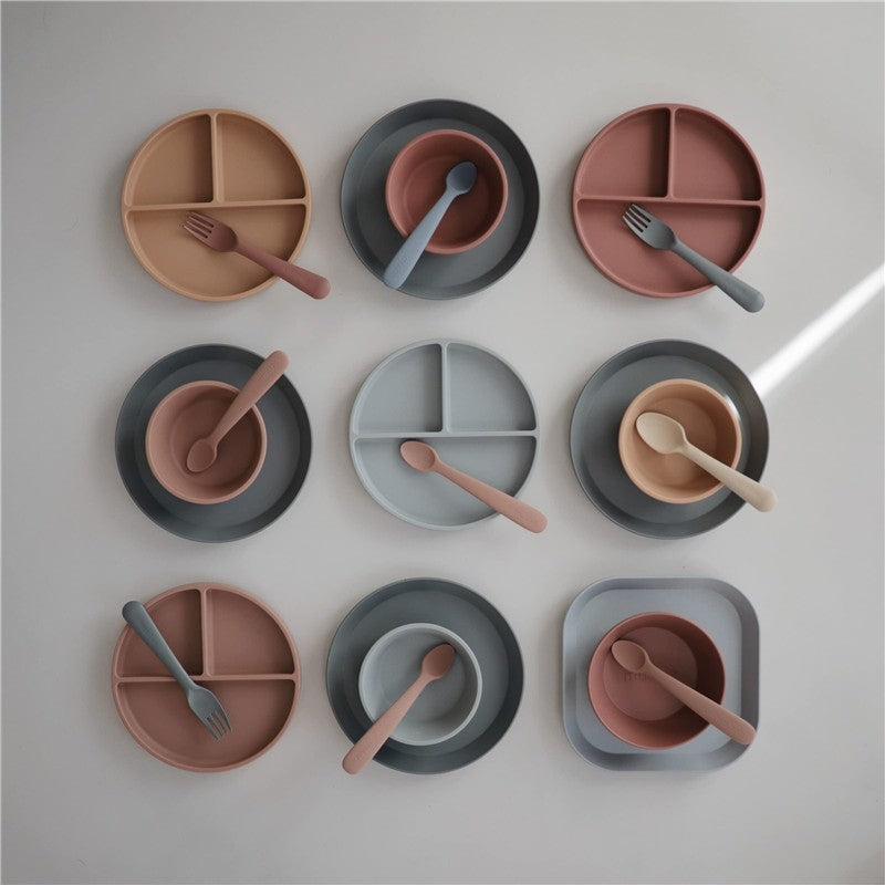 Mushie Silicone Square Plate Dinnerware Set in Cloud colors, featuring various plates and bowls with utensils.