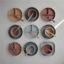 Mushie Silicone Square Plate Dinnerware Set in Cloud colors, featuring various plates and bowls with utensils.