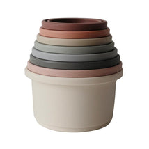 Mushie Stacking Cups set featuring six interlocking cups in soft pastel colors, designed for learning and play.