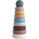 Multi-colored Mushie stacking rings in a tower, featuring a round mint green top ring and various pastel base rings.